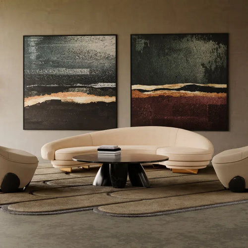 Modern living room with a curved beige sofa, a black marble coffee table, and abstract wall art.