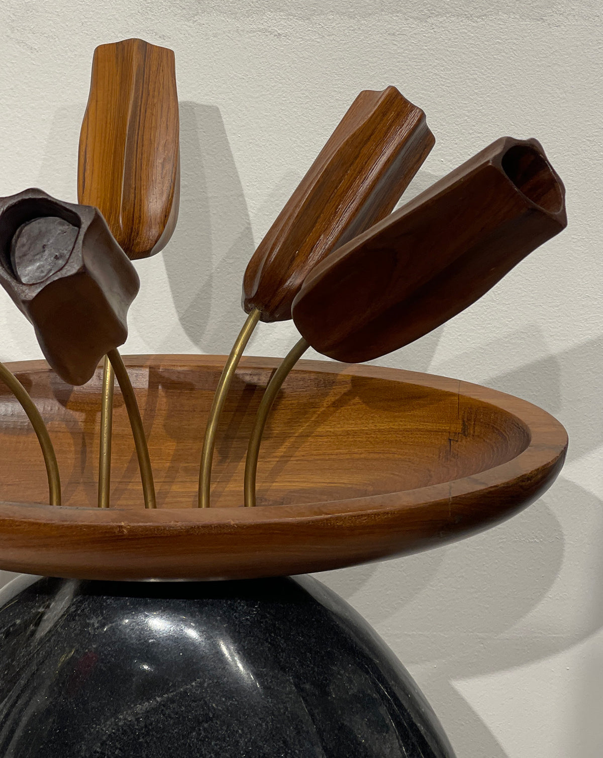 Grounded pairing of dark stone and warm wood for design-led bedroom or dining room interiors