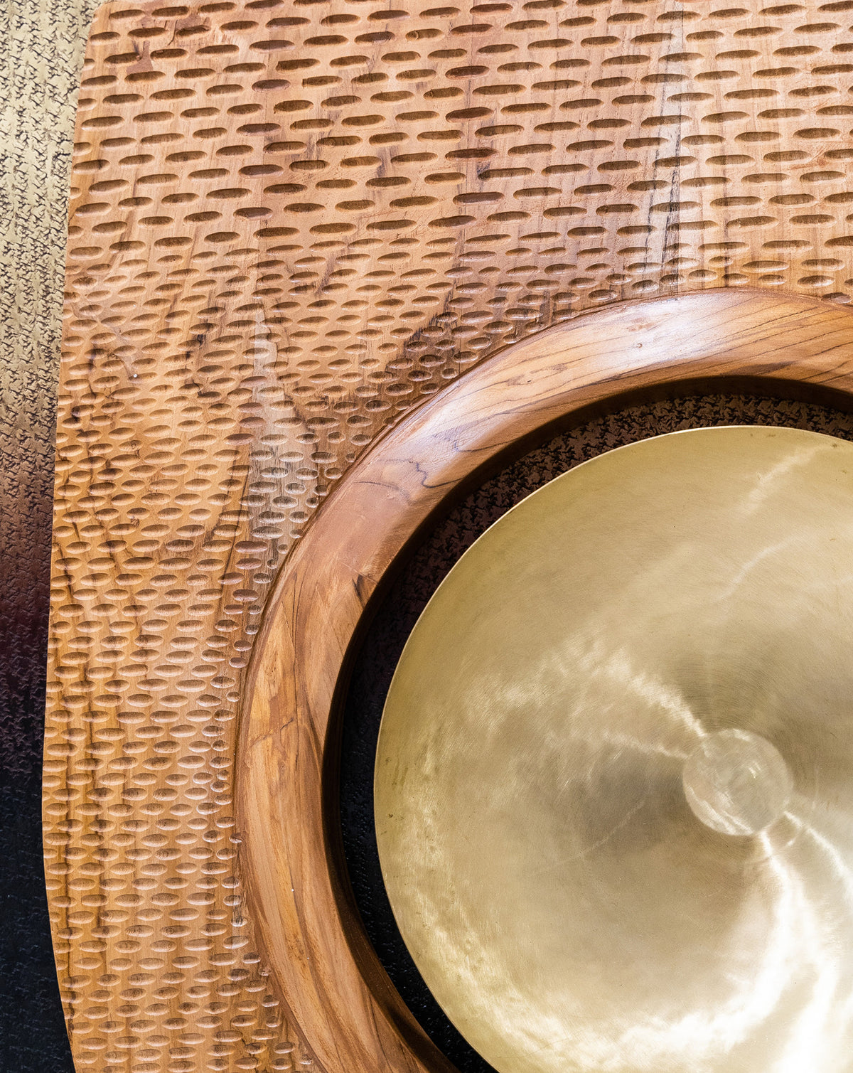Irregular outer silhouette in teak wood resisting uniform geometry across the wall-mounted form