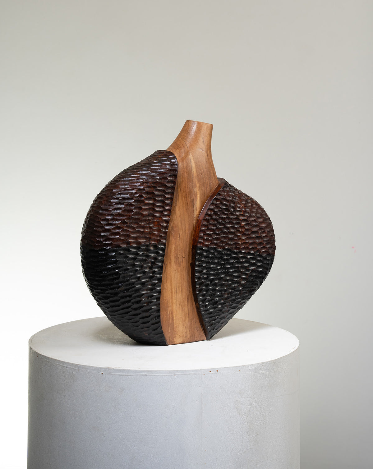 Minimal brown wood form offering quiet contrast against stone or marble surfaces