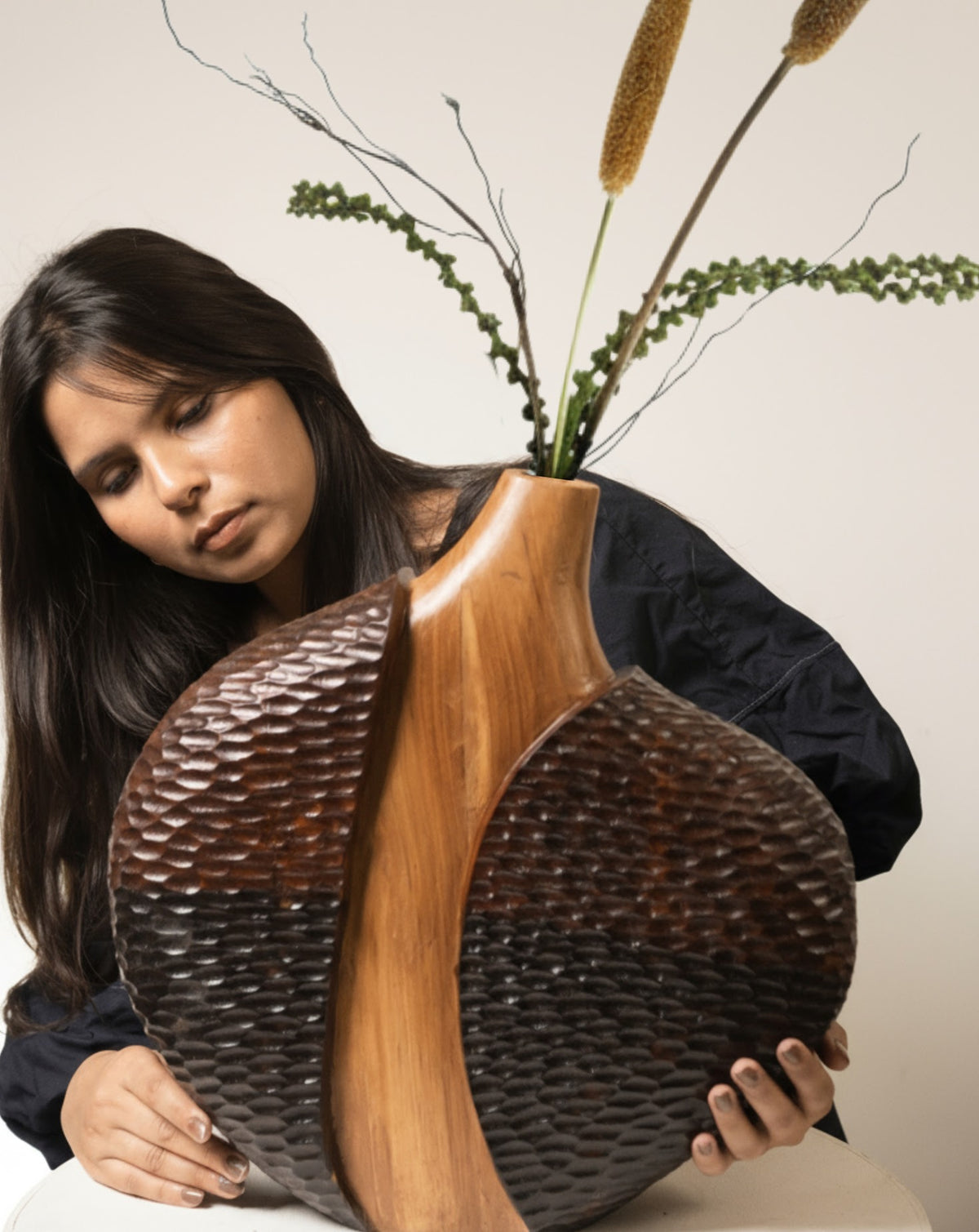 Modern sculptural vase scaled for tabletop display alongside books and ceramics