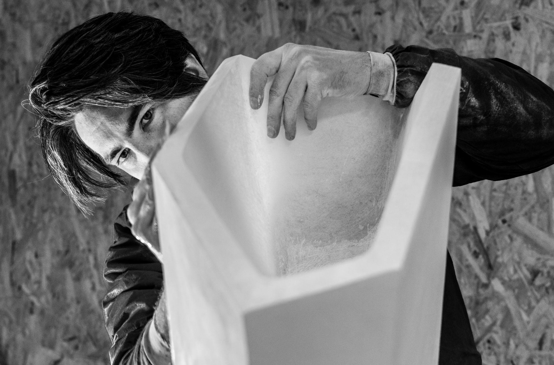 Tom Palmer working closely on a sculptural form, partially obscured behind a large geometric piece.