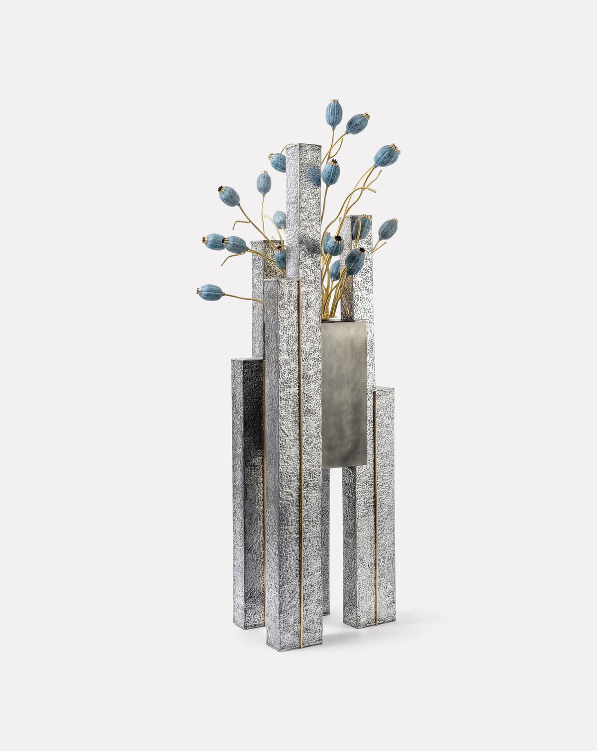 Patinated brass pods on slender stems adding floral softness to raw structure