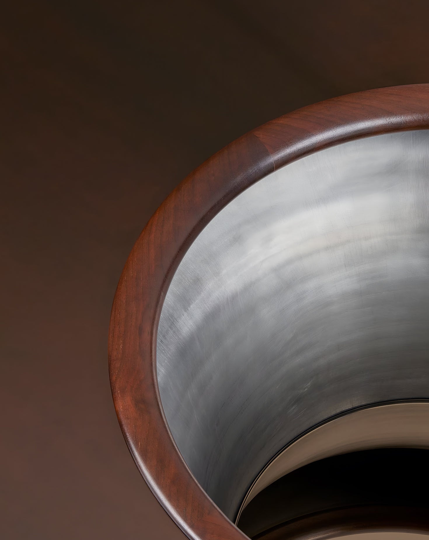 Close-up of a metallic object with a wooden rim on a dark background