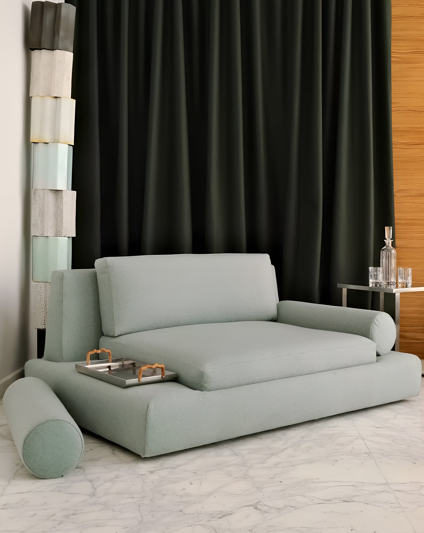 Light gray sofa in a room with a black curtain and wooden wall.