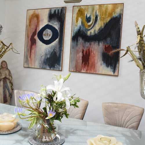 Modern living space with abstract artwork in peach, red, and black above a wooden console.