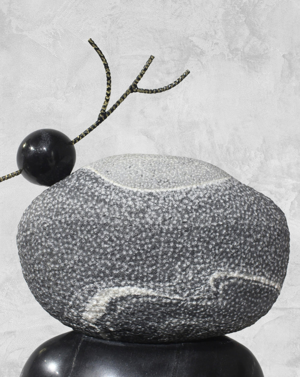 Solid black marble carved into a slender trunk with hand-chiselled textures