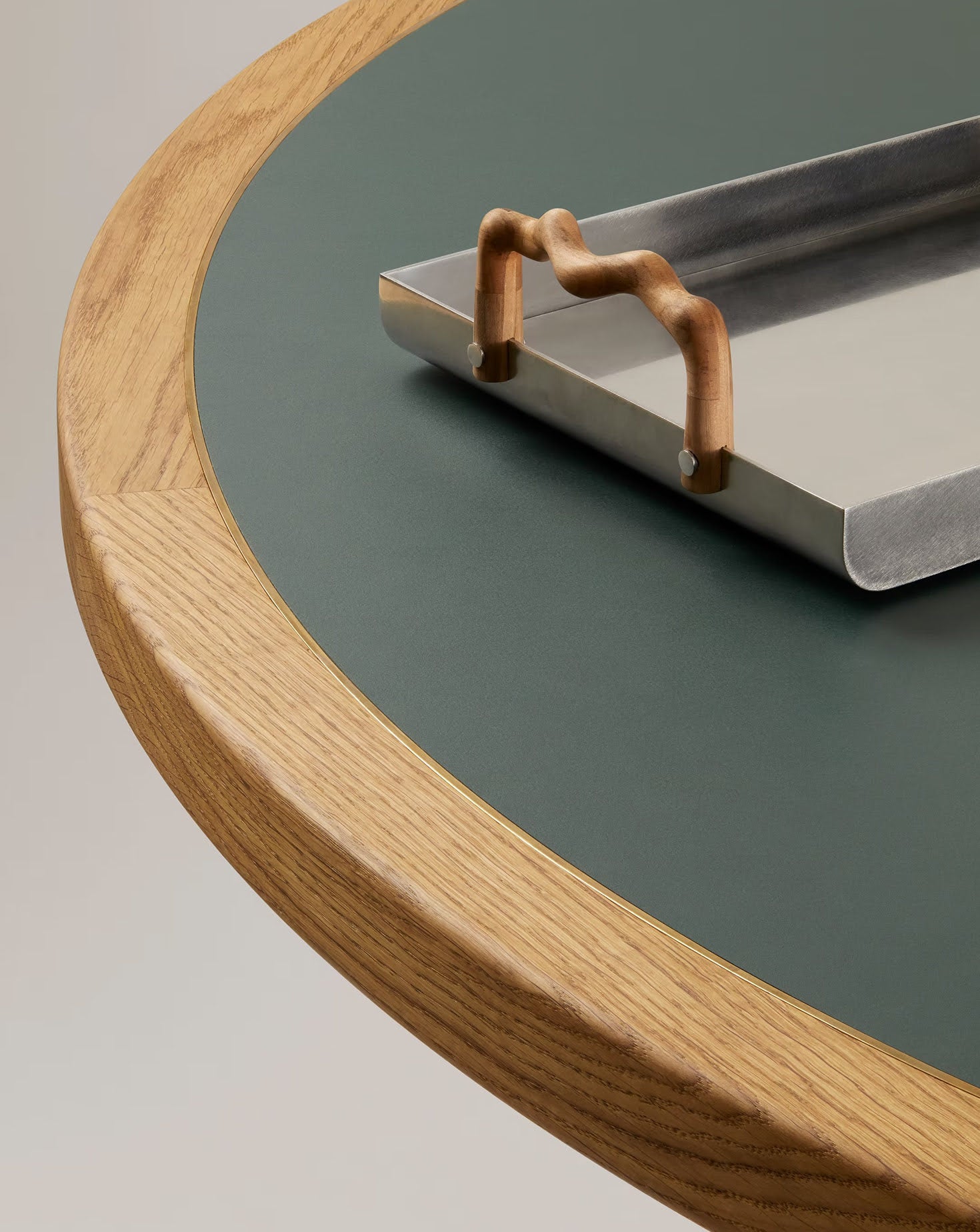 Metallic tray with decorative handle on a round wooden table